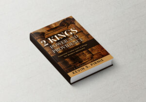 Holding a copy of the book 2 Kings Power and Providence